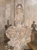 bench end: a lion above grape vines