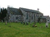 Perpendicular-style windows and buttressing, curious under the shallow tiled roof