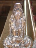 Bench end: grotesque figure with staff