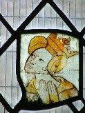 a crowned woman in a kennel headdress gazes up piously