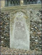 Portrait headstone to the west of the porch 