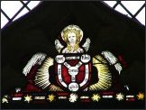 East window glass: angel with Holy Trinity shield