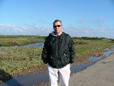 old bloke blowing away cobwebs on Thornham Marshes, 7th May 2005.