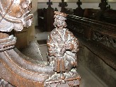 figure in Tudor dress - with a scroll, or grinding with a pestle and mortar?